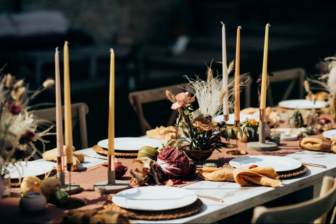 A long wedding reception table set with candles and florals