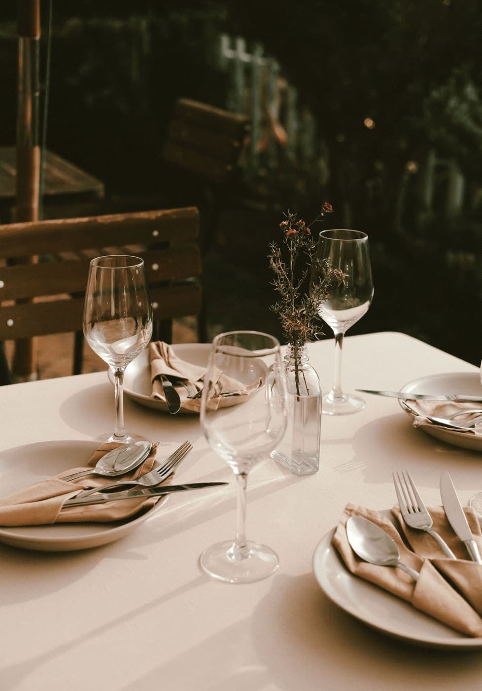 An elegant table place setting with wine glasses