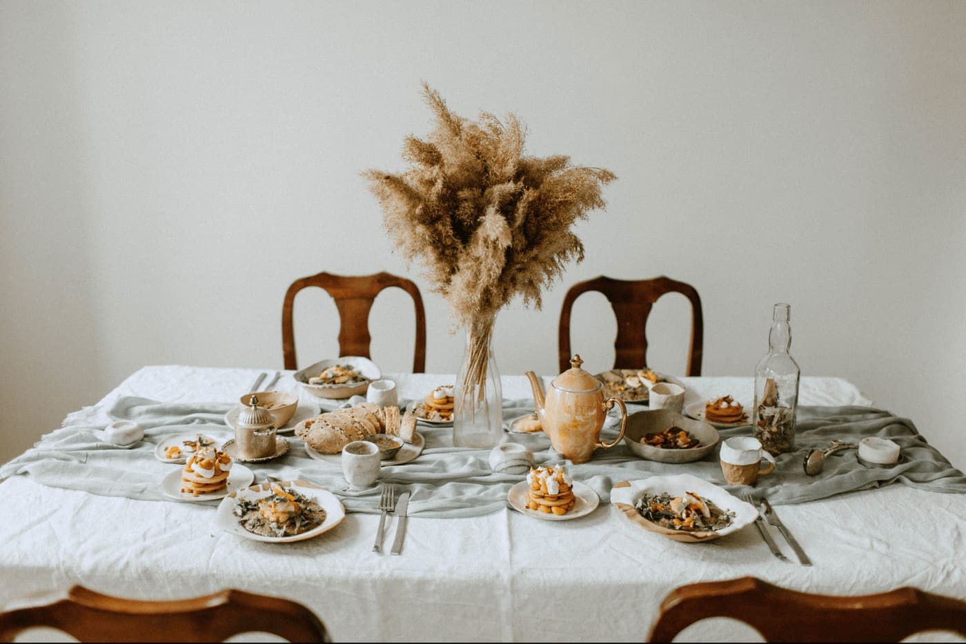 A styled wedding reception table with a pampas grass centerpiece