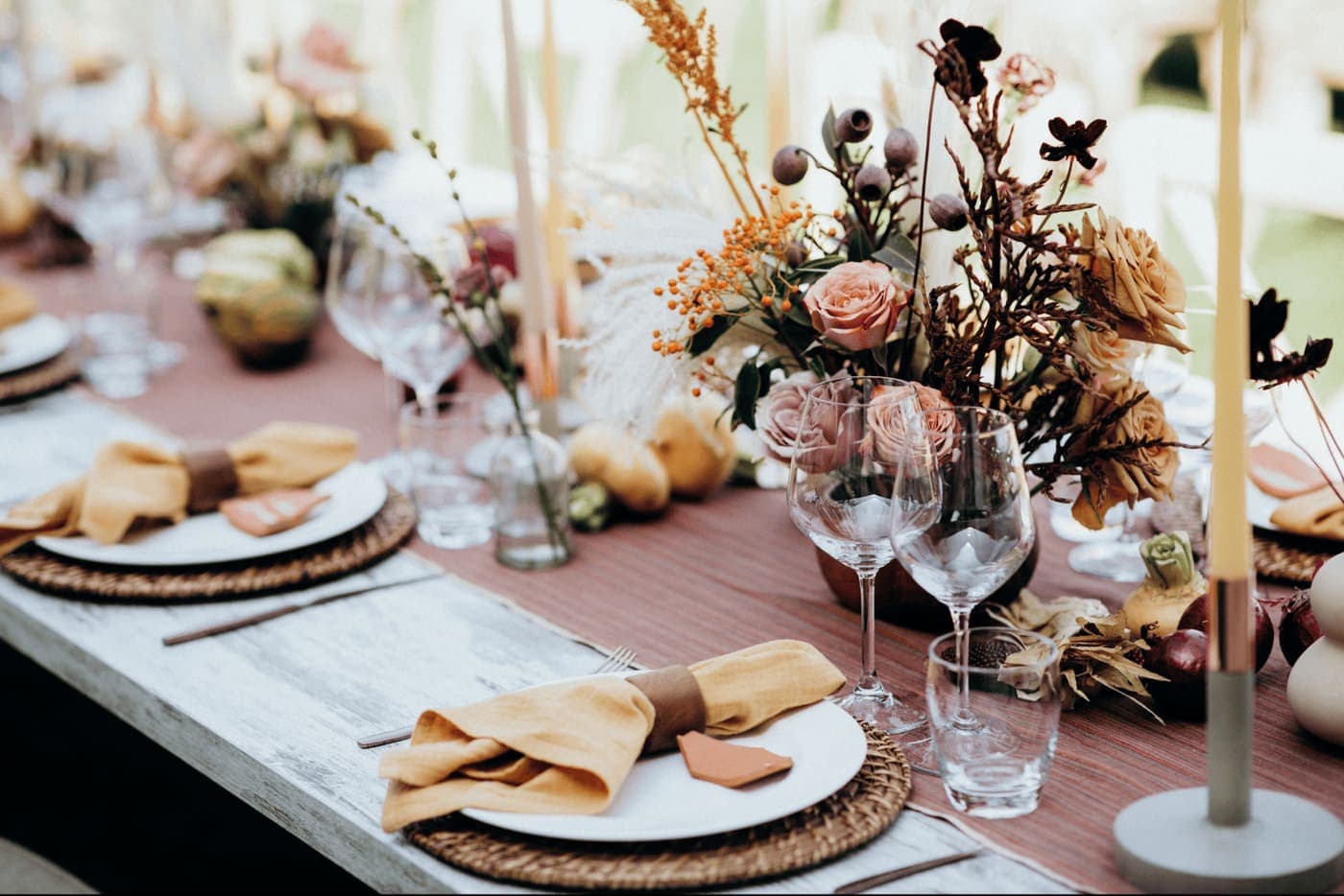 A wedding reception table with floral centerpieces and place settings